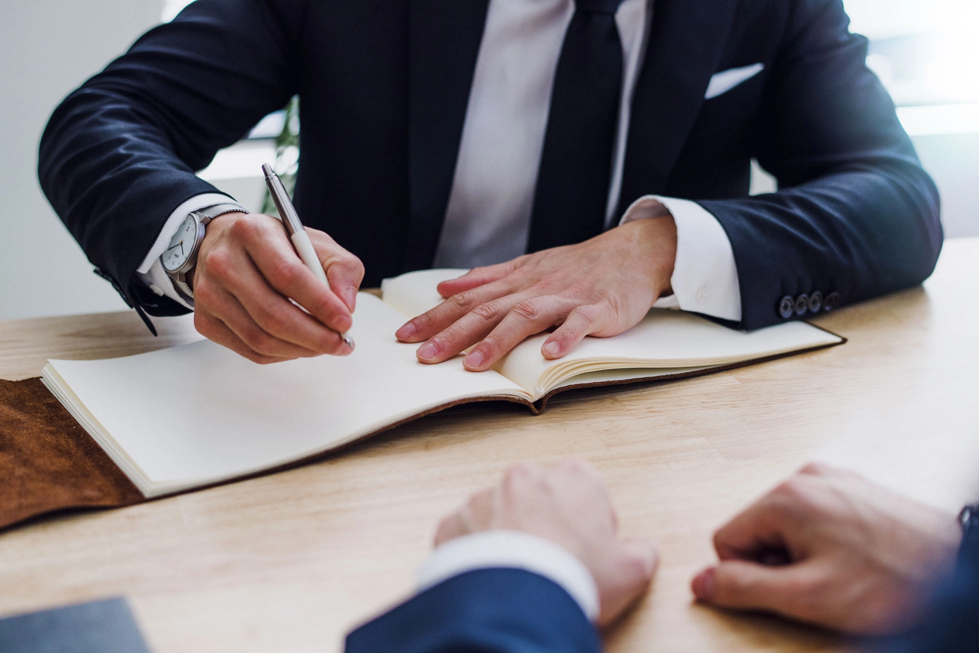law-firm-01 Profesional escribiendo en cuaderno ante cliente